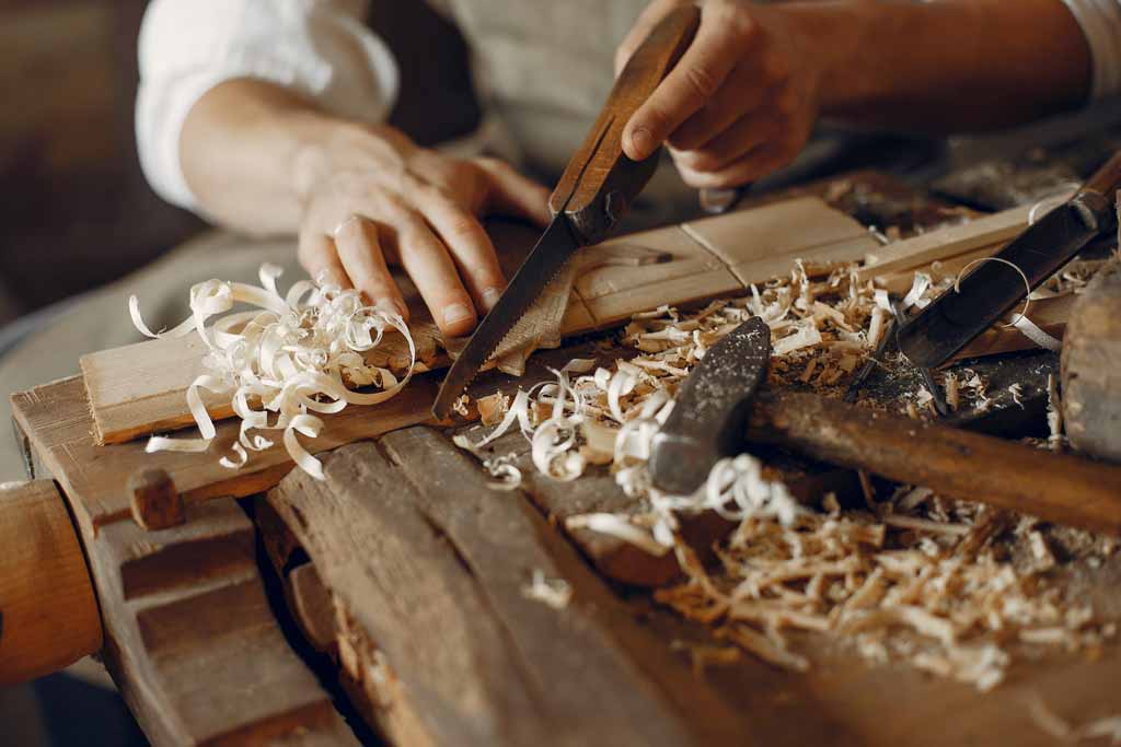 Artesano tallando una pieza de madera a mano en el taller de Astorga